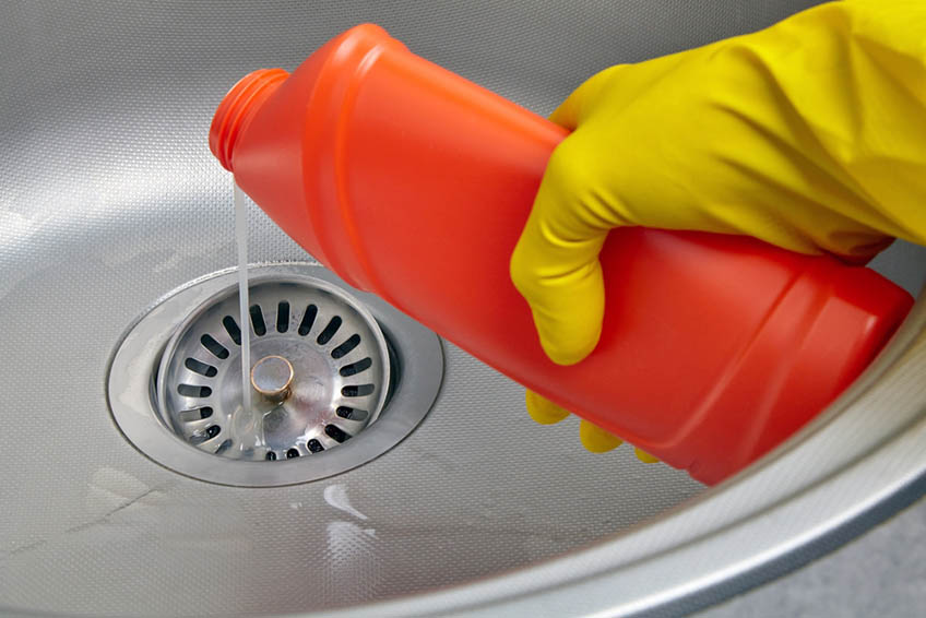 a person pouring chemicals down the drain